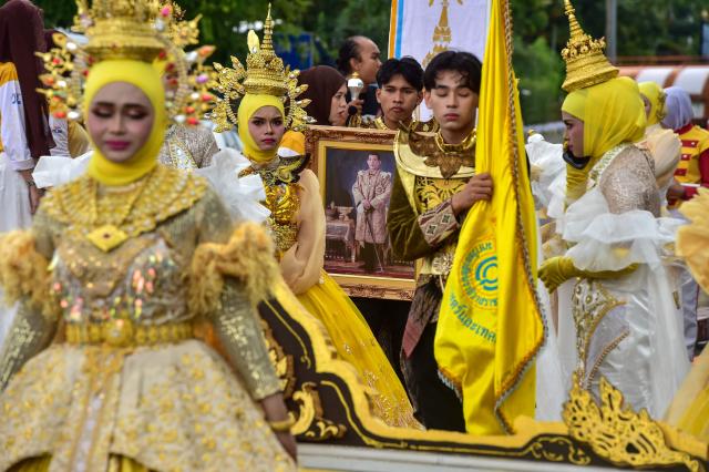 Students from Princess of Naradhiwas University take part in the university's annual parade, with one hold a portrait of Thailand's King Maha Vajiralongkorn, in southern Thailand's predominantly Muslim province of Narathiwat on August 4, 2026.  (Photo by Madaree TOHLALA / AFP)