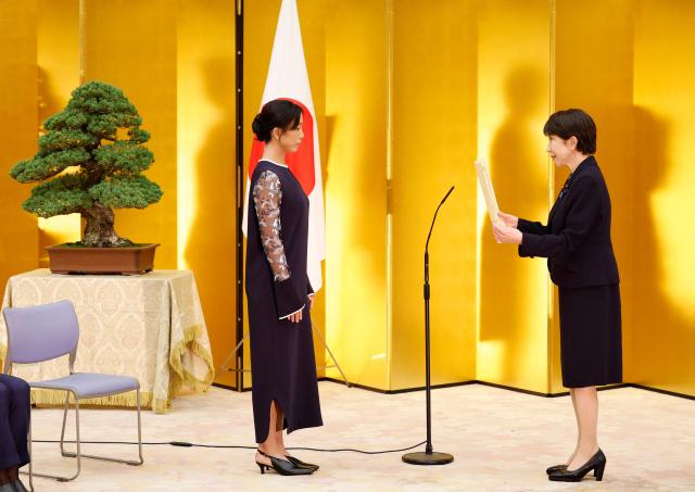 Japanese Prime Minister Sanae Takaichi (R) gives a certification of the People's Honor Award to speed skater Miho Takagi during a ceremony at the prime minister's office in Tokyo on August 4, 2026. (Photo by Franck ROBICHON / POOL / AFP)