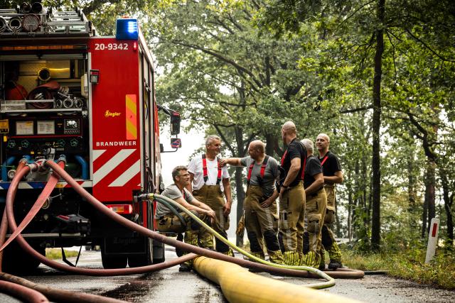 Firefighters take a break as they operate to extinguish a wildfire sweeping through the Boschhuizerbergen nature reserve near Oostrum, in the Dutch municipality of Venray, south-eastern Netherlands on August 4, 2026. (Photo by ROB ENGELAAR / ANP / AFP) / Netherlands OUT