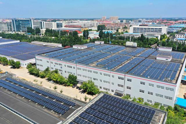 Solar panels are arranged on the rooftop of an industrial park in Jimo District, Qingdao, in eastern China's Shandong province on August 4, 2026. (Photo by CN-STR / AFP) / China OUT