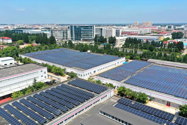 Solar panels are arranged on the rooftop of an industrial park in Jimo District, Qingdao, in eastern China's Shandong province on August 4, 2026. (Photo by CN-STR / AFP) / China OUT