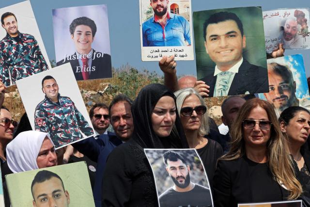 Family members carry the portraits of the victims of 2020 Beirut port blast as they gather near the blast's ground zero on the sixth anniversary of the explosion, in Beirut on August 4, 2026. The massive Beirut port explosion on August 4, 2020, killed more than 220 people, injured more that 6,500 and damaged swathes of the capital. Lebanese authorities have said the explosion was triggered by a fire in a warehouse where tonnes of ammonium nitrate fertiliser had been stored haphazardly for years, despite repeated warnings to senior officials. (Photo by Anwar AMRO / AFP)