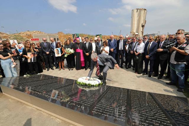 Family members carry the portraits of the victims of 2020 Beirut port blast as they gather alongside ambassadors from several foreign countries around the marble memorial engraved with the names of the victims near the blast's ground zero on the sixth anniversary of the explosion, in Beirut on August 4, 2026. The massive Beirut port explosion on August 4, 2020, killed more than 220 people, injured more that 6,500 and damaged swathes of the capital. Lebanese authorities have said the explosion was triggered by a fire in a warehouse where tonnes of ammonium nitrate fertiliser had been stored haphazardly for years, despite repeated warnings to senior officials. (Photo by Anwar AMRO / AFP)