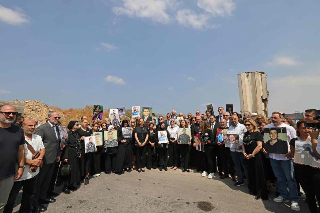 Family members carry the portraits of the victims of 2020 Beirut port blast as they gather alongside ambassadors from several foreign countries near the blast's ground zero on the sixth anniversary of the explosion, in Beirut on August 4, 2026. The massive Beirut port explosion on August 4, 2020, killed more than 220 people, injured more that 6,500 and damaged swathes of the capital. Lebanese authorities have said the explosion was triggered by a fire in a warehouse where tonnes of ammonium nitrate fertiliser had been stored haphazardly for years, despite repeated warnings to senior officials. (Photo by Anwar AMRO / AFP)