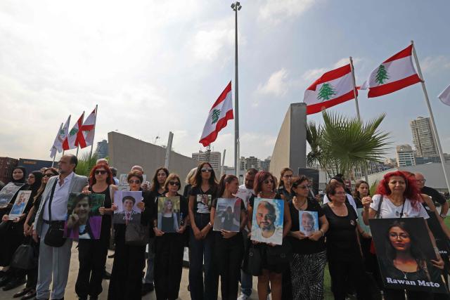 Family members carry the portraits of the victims of 2020 Beirut port blast as they gather near the blast's ground zero on the sixth anniversary of the explosion, in Beirut on August 4, 2026. The massive Beirut port explosion on August 4, 2020, killed more than 220 people, injured more that 6,500 and damaged swathes of the capital. Lebanese authorities have said the explosion was triggered by a fire in a warehouse where tonnes of ammonium nitrate fertiliser had been stored haphazardly for years, despite repeated warnings to senior officials. (Photo by Anwar AMRO / AFP)