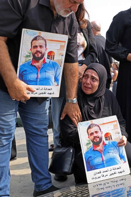 Family members carry the portraits of a victim of 2020 Beirut port blast as they gather around the marble memorial engraved with the names of the victims near the blast's ground zero on the sixth anniversary of the explosion, in Beirut on August 4, 2026. The massive Beirut port explosion on August 4, 2020, killed more than 220 people, injured more that 6,500 and damaged swathes of the capital. Lebanese authorities have said the explosion was triggered by a fire in a warehouse where tonnes of ammonium nitrate fertiliser had been stored haphazardly for years, despite repeated warnings to senior officials. (Photo by Anwar AMRO / AFP)