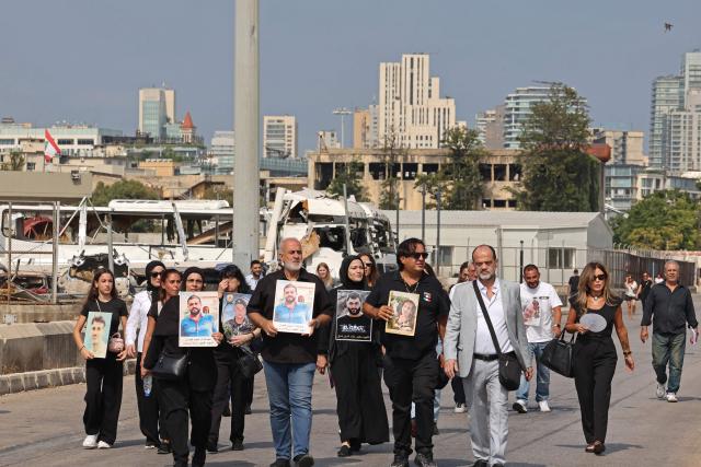 Family members march while carrying the portraits of the victims of 2020 Beirut port blast near the blast's ground zero on the sixth anniversary of the explosion, in Beirut on August 4, 2026. The massive Beirut port explosion on August 4, 2020, killed more than 220 people, injured more that 6,500 and damaged swathes of the capital. Lebanese authorities have said the explosion was triggered by a fire in a warehouse where tonnes of ammonium nitrate fertiliser had been stored haphazardly for years, despite repeated warnings to senior officials. (Photo by Anwar AMRO / AFP)