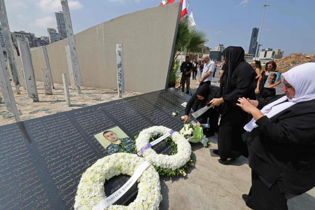 Family members of the victims of 2020 Beirut port blast gather around the marble memorial engraved with the names of the victims near the blast's ground zero on the sixth anniversary of the explosion, in Beirut on August 4, 2026. The massive Beirut port explosion on August 4, 2020, killed more than 220 people, injured more that 6,500 and damaged swathes of the capital. Lebanese authorities have said the explosion was triggered by a fire in a warehouse where tonnes of ammonium nitrate fertiliser had been stored haphazardly for years, despite repeated warnings to senior officials. (Photo by Anwar AMRO / AFP)