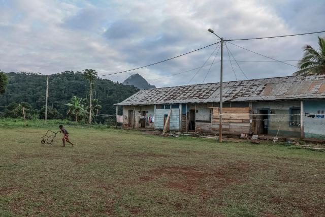 A boy runs through the playground of Sao Jose Sanzalas, the barracks or residential quarters built to house the forced labourers and workers at the Roca Sao Jose, near Santo Antonio, in Principe Island in Sao Tome and Principe, on August 3, 2026. Roca Sao Jose is a former colonial plantation (roca) situated on the island of Principe. It forms part of the rich heritage of the cocoa and coffee plantations in the archipelago of Sao Tome and Principe. (Photo by Daniel BELOUMOU OLOMO / AFP)