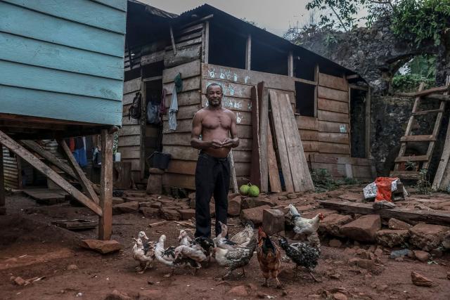 Jose, a resident of Sao Jose, poses for a photograph in front of his house in Principe Island in Sao Tome and Principe, on August 3, 2026. (Photo by Daniel BELOUMOU OLOMO / AFP)