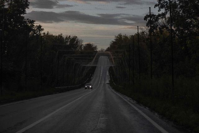 A car drives along a road covered with anti-drone nets in the eastern Kharkiv region on July 29, 2026, amid the Russian invasion of Ukraine. (Photo by Roman PILIPEY / AFP)