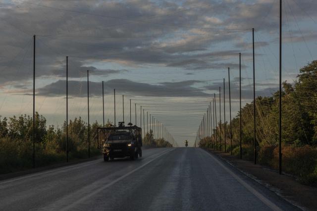 A military car equipped with additional anti-drone protection drives along a road covered with anti-drone nets in the eastern Kharkiv region on July 29, 2026, amid the Russian invasion of Ukraine. (Photo by Roman PILIPEY / AFP)