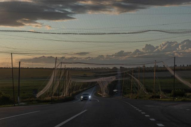 TOPSHOT - A car drives along a road covered with anti-drone nets in the eastern Kharkiv region on July 29, 2026, amid the Russian invasion of Ukraine. (Photo by Roman PILIPEY / AFP)