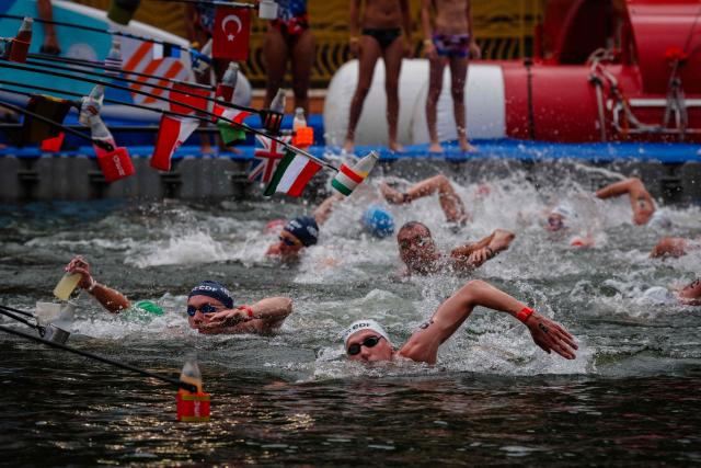 Swimmers compete past a feeding station in the men's 10km open water swimming event during the LEN European Aquatics Championships, in the Seine River in Paris, on August 4, 2026. (Photo by Dimitar DILKOFF / AFP)