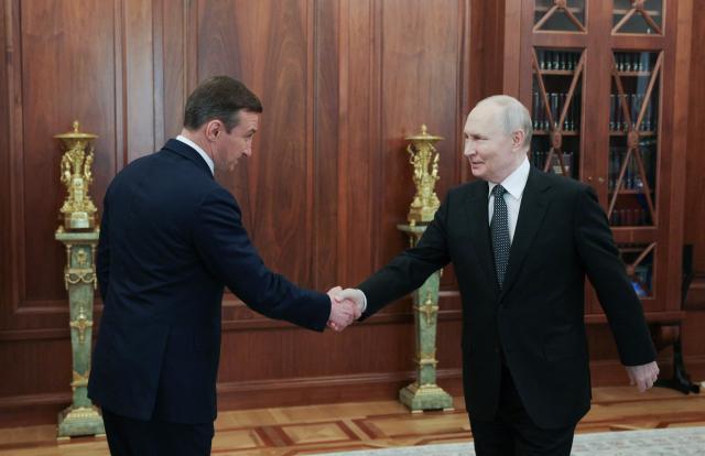 In this pool photograph distributed by the Russian state agency Sputnik, Russia's President Vladimir Putin shakes hands with Pavel Marinychev, chief executive officer of Russia's state-run diamond giant Alrosa, during a meeting in Moscow on August 4, 2026. (Photo by Alexander KAZAKOV / POOL / AFP)