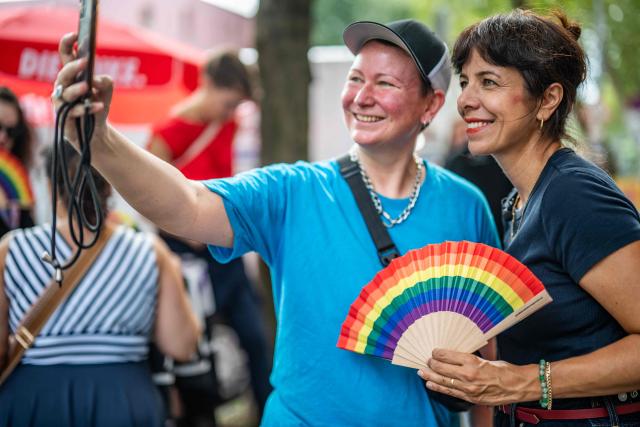 The Left Party's (Die Linke) main candidate in upcoming regional elections in Berlin Elif Eralp (R) poses for a selfie at a cafe during a campaign stop in Berlin's Schoeneberg district on August 4, 2026. Berlin goes to the polls on September 20, 2026. (Photo by John MACDOUGALL / AFP)