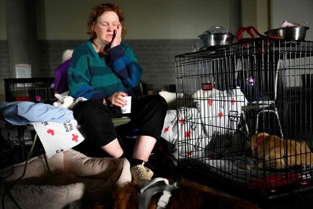 A woman waits with her pets for news on the status of her home at a Red Cross evacuation center in Spokane, Washington, on August 4, 2026. US authorities arrested a man on August 3, 2026 on suspicion of arson in connection with the biggest of three fires burning around the northwestern city of Spokane, as firefighters raced to contain flames that have displaced tens of thousands. Wildfires supercharged by drought and intense heat have torn through the city in Washington state, burning thousands of acres and reducing hundreds of buildings to cinders while anxious families await news on when they can return. (Photo by Josh Edelson / AFP)