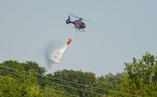 A police helicoptor helping to tackle the blaze flies overhead near the scene of a forest fire in Vienna, Austria, on August 4, 2026. Austria set a new temperature record on August 4, 2026 with 40.8C measured in Vienna, the national weather agency said. (Photo by GEORG HOCHMUTH / APA / AFP) / Austria OUT