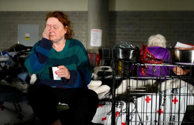 A woman waits with her pets for news on the status of her home at a Red Cross evacuation center in Spokane, Washington, on August 4, 2026. US authorities arrested a man on August 3, 2026 on suspicion of arson in connection with the biggest of three fires burning around the northwestern city of Spokane, as firefighters raced to contain flames that have displaced tens of thousands. Wildfires supercharged by drought and intense heat have torn through the city in Washington state, burning thousands of acres and reducing hundreds of buildings to cinders while anxious families await news on when they can return. (Photo by Josh Edelson / AFP)