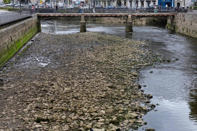 This photograph shows the dried-out riverbed of the Odet River in Quimper, north-western France on August 4, 2026, as a heatwave hits France. The basin of the Odet river faces a "drought crisis," according to the Finistère prefecture. (Photo by Fred TANNEAU / AFP)