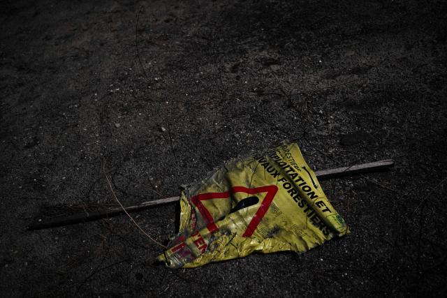 This photograph shows a melted road sign in a forest following a wildfire which engulfed the Gironde region in Lege-Cap-Ferret, southwestern France on August 4, 2026. (Photo by Christophe ARCHAMBAULT / AFP)