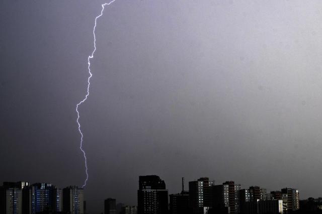 A lightning fork illuminates the sky above Ukraine's capital during a thunderstorm in Kyiv on August 4, 2026. (Photo by Sergei SUPINSKY / AFP)