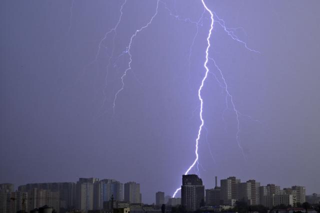 Lightning forks illuminate the sky above Ukraine's capital during a thunderstorm in Kyiv on August 4, 2026. (Photo by Sergei SUPINSKY / AFP)