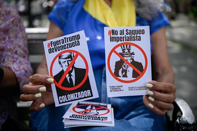 A woman holds flyers depicting US President Donald Trump and symbol Uncle Sam during a protest against US interference in Venezuela at El Venezolano Square in Caracas on August 4, 2026. (Photo by Federico PARRA / AFP)