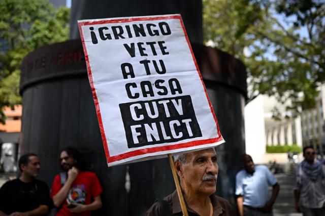 A man holds a sign that reads in Spanish "Gringo Go Home" during a protest against US interference in Venezuela at El Venezolano Square in Caracas on August 4, 2026. (Photo by Federico PARRA / AFP)