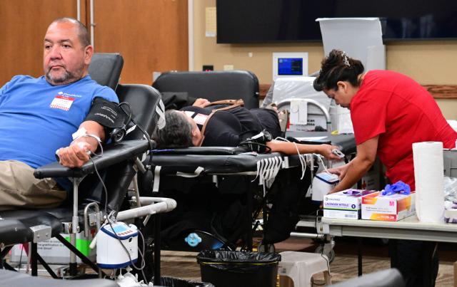 An American Red Cross staff member assists people donating blood during a blood drive amid an urgent need for donors at Providence St. Jude Medical Center in Fullerton, California, on August 4, 2026. The American Red Cross has declared its second-ever national blood supply crisis after donations fell to a four-year summer low, prompting a national emergency over declining blood supplies. (Photo by Frederic J. BROWN / AFP)