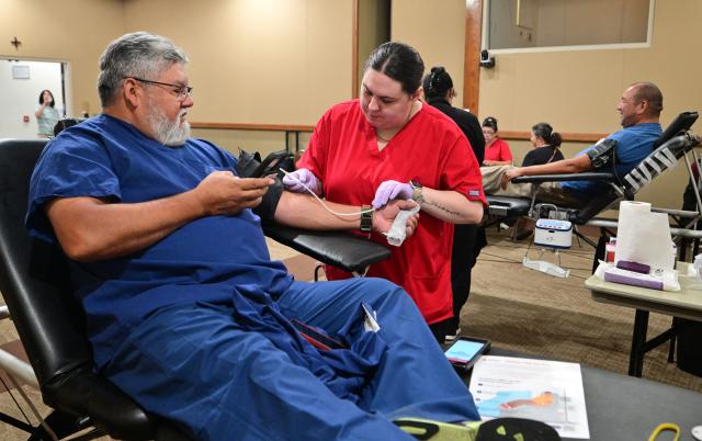 An American Red Cross staff member assists a man donating blood during a blood drive amid an urgent need for donors at Providence St. Jude Medical Center in Fullerton, California, on August 4, 2026. The American Red Cross has declared its second-ever national blood supply crisis after donations fell to a four-year summer low, prompting a national emergency over declining blood supplies. (Photo by Frederic J. BROWN / AFP)