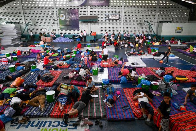 Evacuees rest at a shelter after fleeing their village following the eruption of Fuego volcano in Escuintla, Guatemala, on August 4, 2026. Guatemalan authorities issued the country's second-highest emergency alert level on August 4 after a major eruption of Central America's most active volcano, prompting the evacuation of nearby villages. (Photo by Johan ORDONEZ / AFP)