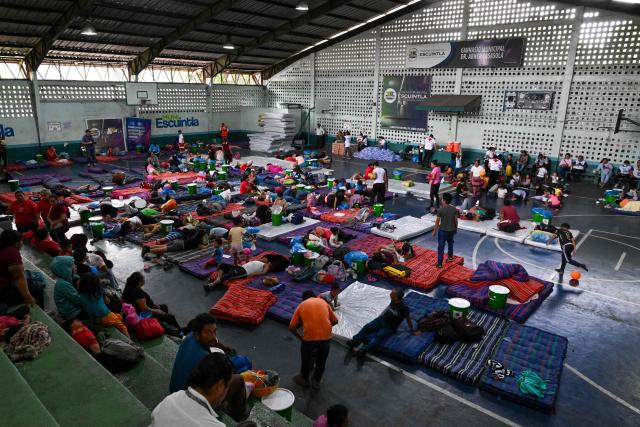 Evacuees rest at a shelter after fleeing their village following the eruption of Fuego volcano in Escuintla, Guatemala, on August 4, 2026. Guatemalan authorities issued the country's second-highest emergency alert level on August 4 after a major eruption of Central America's most active volcano, prompting the evacuation of nearby villages. (Photo by Johan ORDONEZ / AFP)