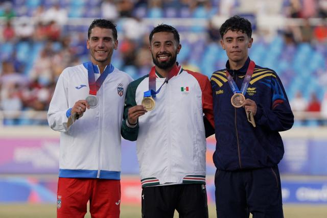 Mexico's Eduardo Herrera (C), Puerto Rico's Victor Ortiz (L) and Colombia's Pedro Marin pose on the podium after winning the gold, silver and bronze medals, respectively, in the men's 5000m final during the XXV Central American and Caribbean Games at the Felix Sanchez Olympic Stadium in Santo Domingo on August 3, 2026. (Photo by Francesco SPOTORNO / AFP)