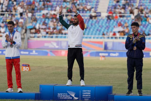 Mexico's Eduardo Herrera (C), Puerto Rico's Victor Ortiz (L) and Colombia's Pedro Marin pose on the podium after winning the gold, silver and bronze medals, respectively, in the men's 5000m final during the XXV Central American and Caribbean Games at the Felix Sanchez Olympic Stadium in Santo Domingo on August 3, 2026. (Photo by Francesco SPOTORNO / AFP)