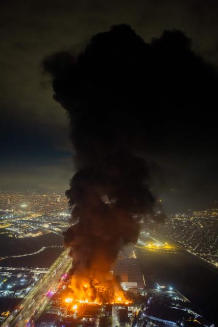 This aerial view shows a large fire at a chemical plant in the Quilicura commune of Santiago on August 4, 2026. (Photo by Javier TORRES / AFP)