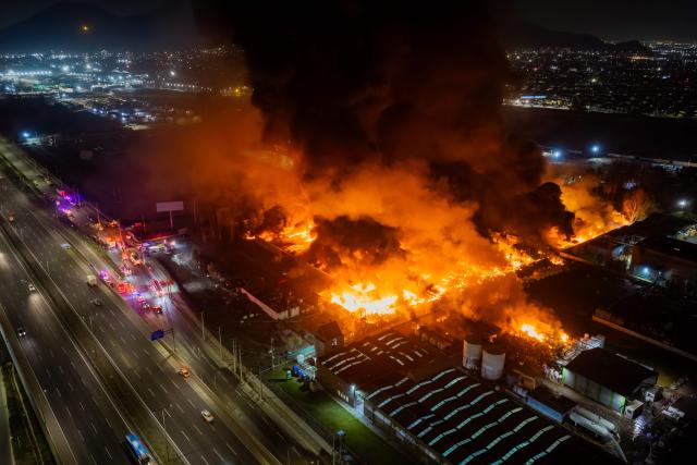 This aerial view shows a large fire at a chemical plant in the Quilicura commune of Santiago on August 4, 2026. (Photo by Javier TORRES / AFP)