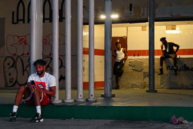 Residents in a neighborhood remain outside of their houses during a blackout in Havana on August 4, 2026. (Photo by ADALBERTO ROQUE / AFP)