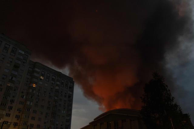 This photograph shows smoke rising from a warehouse destroyed during massive Russian ballistic missile and drone strikes next to a residential building on the outskirts of Kyiv early on August 5, 2026, amid the Russian invasion of Ukraine. Russian strikes on Ukraine's capital and surrounding region killed at least two people and wounded dozens more, authorities said on August 5, 2026, after fresh overnight missile and drone attacks. (Photo by Roman PILIPEY / AFP)