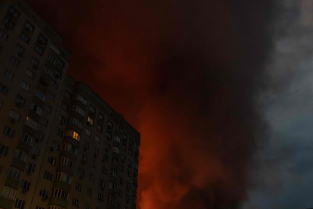 This photograph shows smoke rising from a warehouse destroyed during massive Russian ballistic missile and drone strikes next to a residential building on the outskirts of Kyiv early on August 5, 2026, amid the Russian invasion of Ukraine. Russian strikes on Ukraine's capital and surrounding region killed at least two people and wounded dozens more, authorities said on August 5, 2026, after fresh overnight missile and drone attacks. (Photo by Roman PILIPEY / AFP)