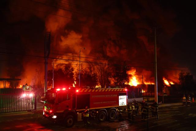 Firefighters battle a large fire at a chemical plant in the Quilicura commune of Santiago on August 4, 2026. (Photo by Javier TORRES / AFP)