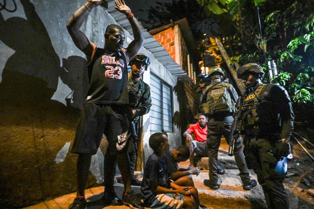 Colombian soldiers frisk a man in the Melendez neighborhood prior to the upcoming presidential inauguration of Colombia's president-elect Abelardo de la Espriella, in Cali, Colombia, on August 4, 2026. De la Espriella's inauguration will take place on August 7, 2026. (Photo by JOAQUIN SARMIENTO / AFP)