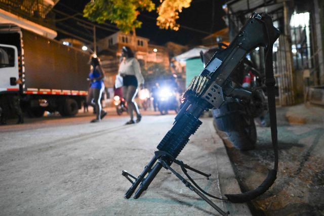 Colombian policemen and solldiers stand guard as people transit in the Melendez neighborhood prior to the upcoming presidential inauguration of Colombia's president-elect Abelardo de la Espriella, in Cali, Colombia, on August 4, 2026. De la Espriella's inauguration will take place on August 7, 2026. (Photo by JOAQUIN SARMIENTO / AFP)