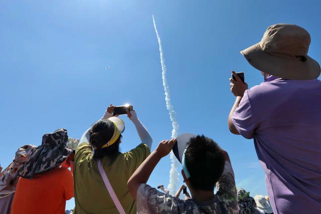 People watch as a Jielong-3 carrier rocket carrying two satellites, the Dongfang Huiyan Hyperspectral 01 and 02, lifts off along the coast of Haiyang in eastern China's Shandong province on August 5, 2026. (Photo by CN-STR / AFP) / China OUT