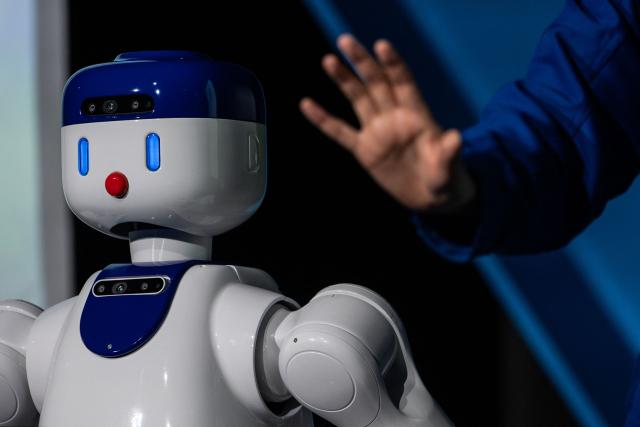 Zeals CEO Masahiro Shimizu (R) gestures next to the company's semi-domestic compact humanoid "D1" helper robot during a press preview at Shibuya Scramble Hall in Tokyo on August 5, 2026. (Photo by Andrew CABALLERO-REYNOLDS / AFP)