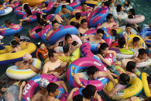 People pack into a wave pool at an ocean park as they seek relief from the heat in Shenyang, northeastern China's Liaoning province on August 4, 2026. (Photo by CN-STR / AFP) / China OUT