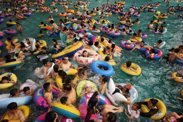 People pack into a wave pool at an ocean park as they seek relief from the heat in Shenyang, northeastern China's Liaoning province on August 4, 2026. (Photo by CN-STR / AFP) / China OUT