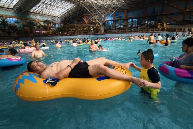 People pack into a wave pool at an ocean park as they seek relief from the heat in Shenyang, northeastern China's Liaoning province on August 4, 2026. (Photo by CN-STR / AFP) / China OUT