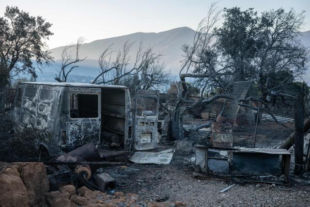 This photograph taken on August 5, 2026, shows the remains of a house destroyed after a wildfire in Porto Germeno, some 70 kilometers (45 miles) northwest of Athens. Greek officials and residents of a region west of the capital Athens on August 5, 2026, began to assess the damage suffered by homes, businesses and farmland scorched by a wildfire. (Photo by Angelos TZORTZINIS / AFP)