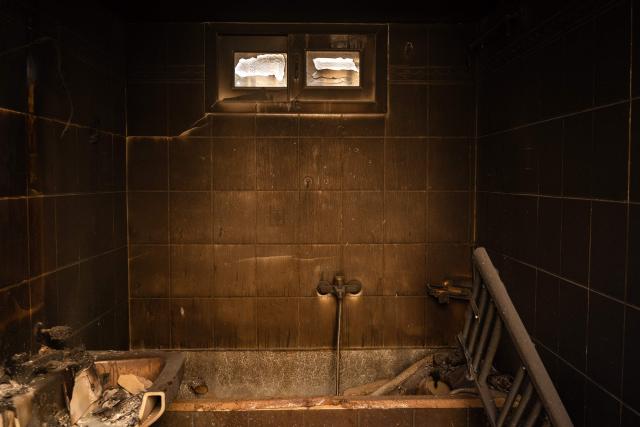 This photograph taken on August 5, 2026, shows the interior of a house destroyed after a wildfire in Porto Germeno, some 70 kilometers (45 miles) northwest of Athens. Greek officials and residents of a region west of the capital Athens on August 5, 2026, began to assess the damage suffered by homes, businesses and farmland scorched by a wildfire. (Photo by Angelos TZORTZINIS / AFP)